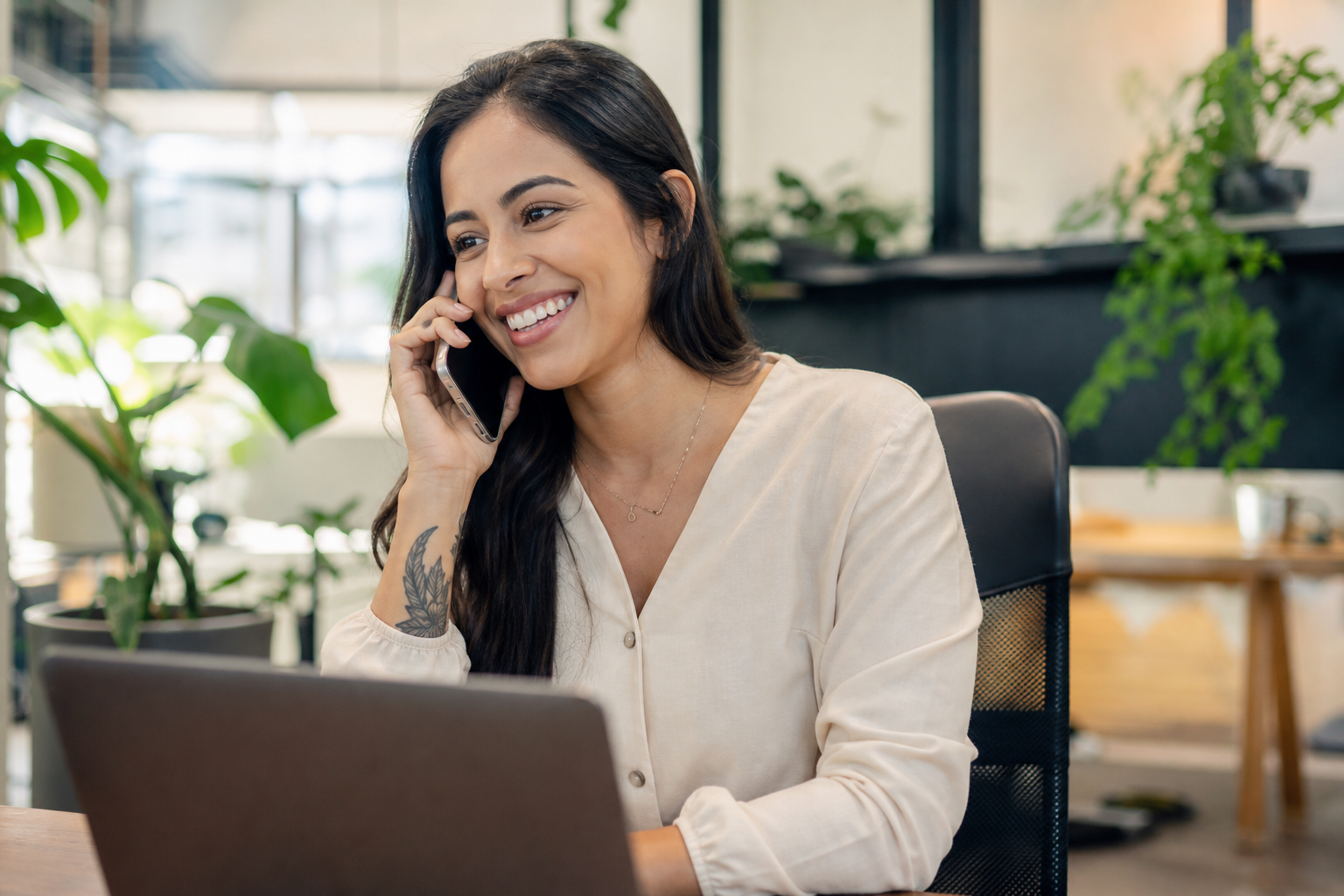 Atendente brasileira sorrindo ao telefone em escritório iluminado — Almira Brasil